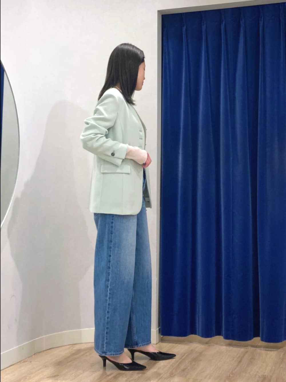 グリーン系のノーカラージャケット、ホワイト系のTシャツ/カットソー、ブルー系のデニムパンツを着用したレディースの冬コーディネートの4枚目の写真