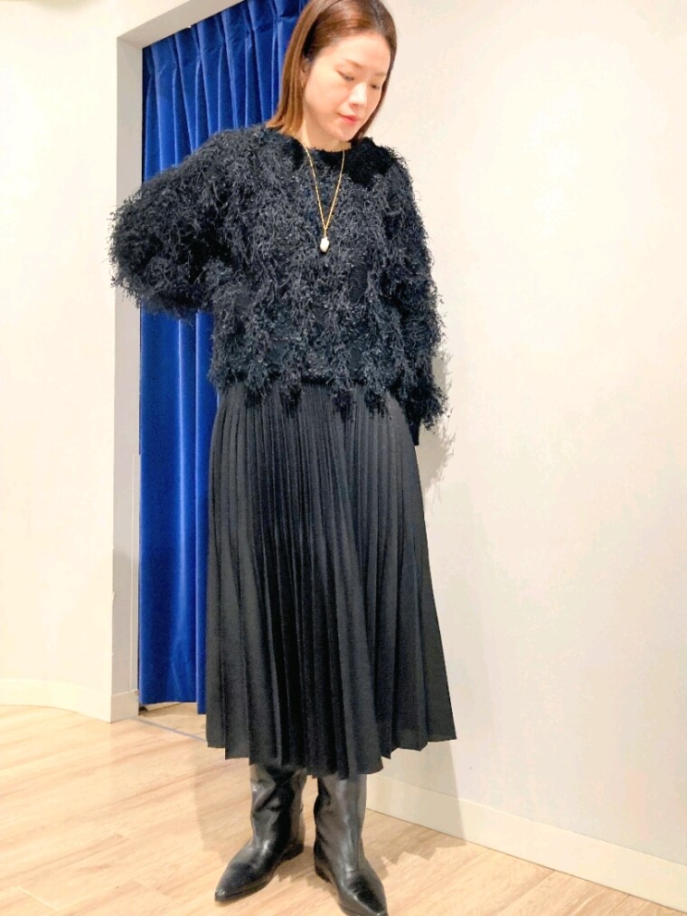 ブラック系のニット/セーター、グレー系のバッグ、ホワイト系のダウンジャケット/コートを着用したレディースの秋コーディネートの6枚目の写真