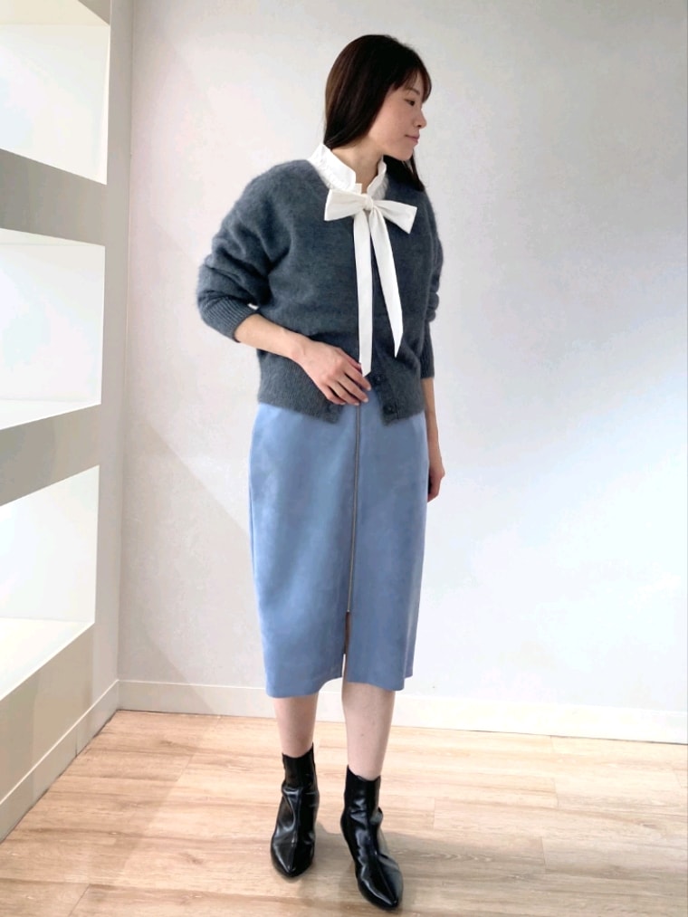 ホワイト系のシャツ/ブラウス、グレー系のカーディガン/ボレロ、ブルー系のスカートを着用したレディースの秋コーディネートの3枚目の写真