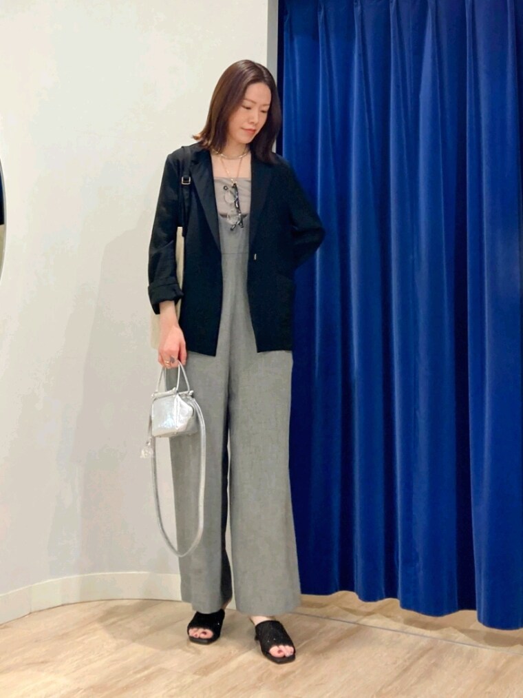 ブラック系のテーラードジャケット、グリーン系のキャミソール、グレー系のつなぎ/オールインワンを着用したレディースの春コーディネートの9枚目の写真
