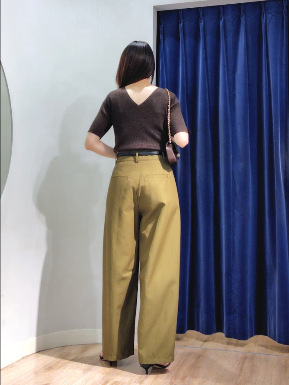 グリーン系のチノパンツ、ブラウン系のニット/セーター、ブラウン系のショルダーバッグを着用したレディースの秋コーディネートの5枚目の写真