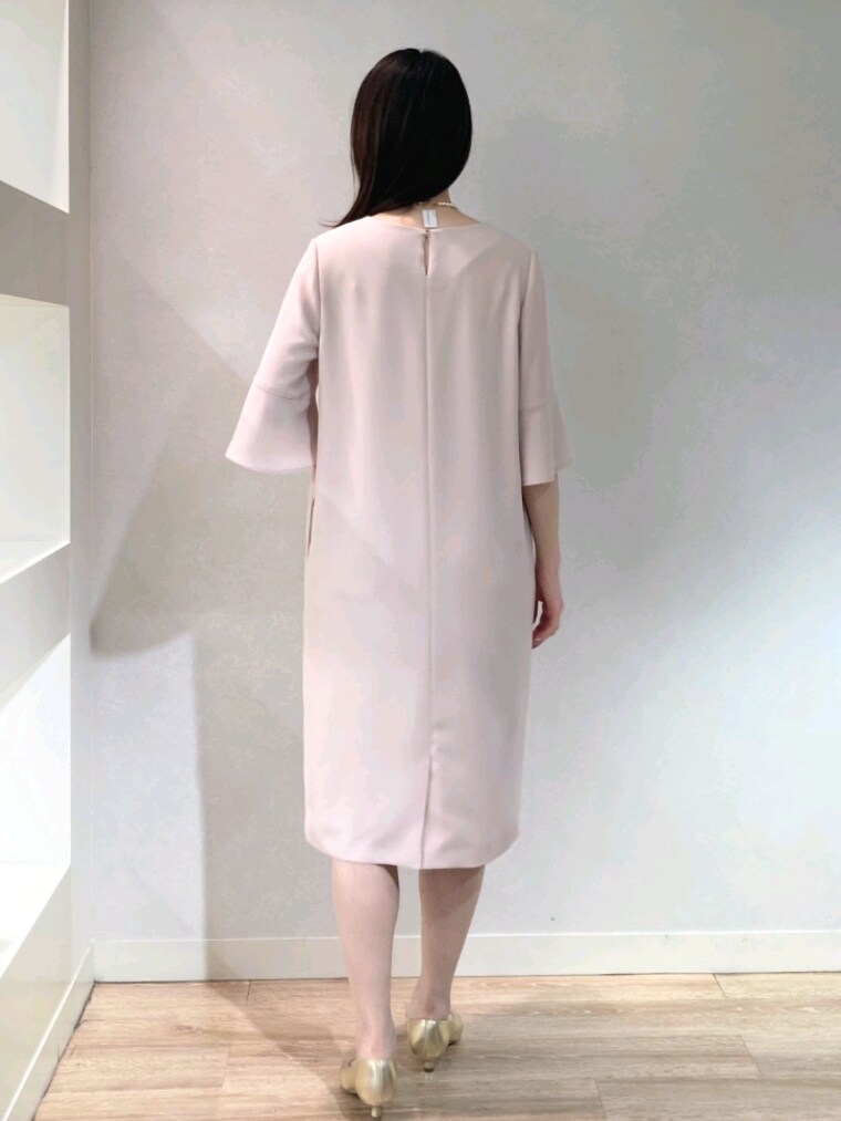 ピンク系のワンピース、ゴールド系のパンプス、ホワイト系のショルダーバッグを着用したレディースの春コーディネートの6枚目の写真