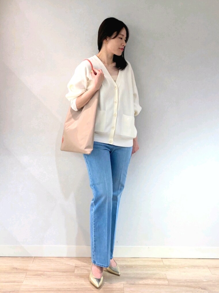 ホワイト系のニット/セーター、ゴールド系のキャミソール、ブルー系のデニムパンツを着用したレディースの春コーディネートの3枚目の写真