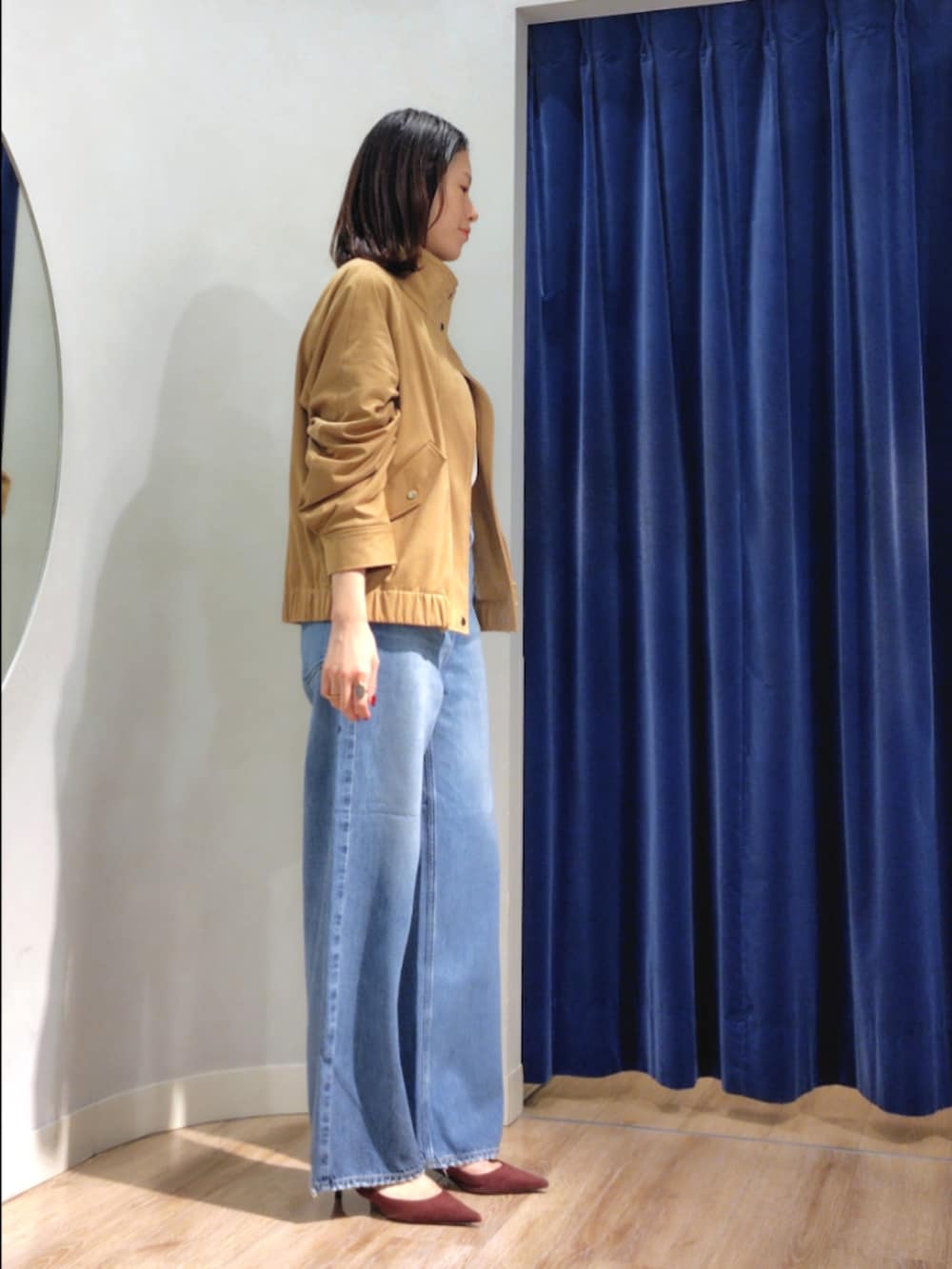 ブルー系のシャツ/ブラウス、イエロー系のブルゾン、ブルー系のデニムパンツを着用したレディースの秋コーディネートの4枚目の写真