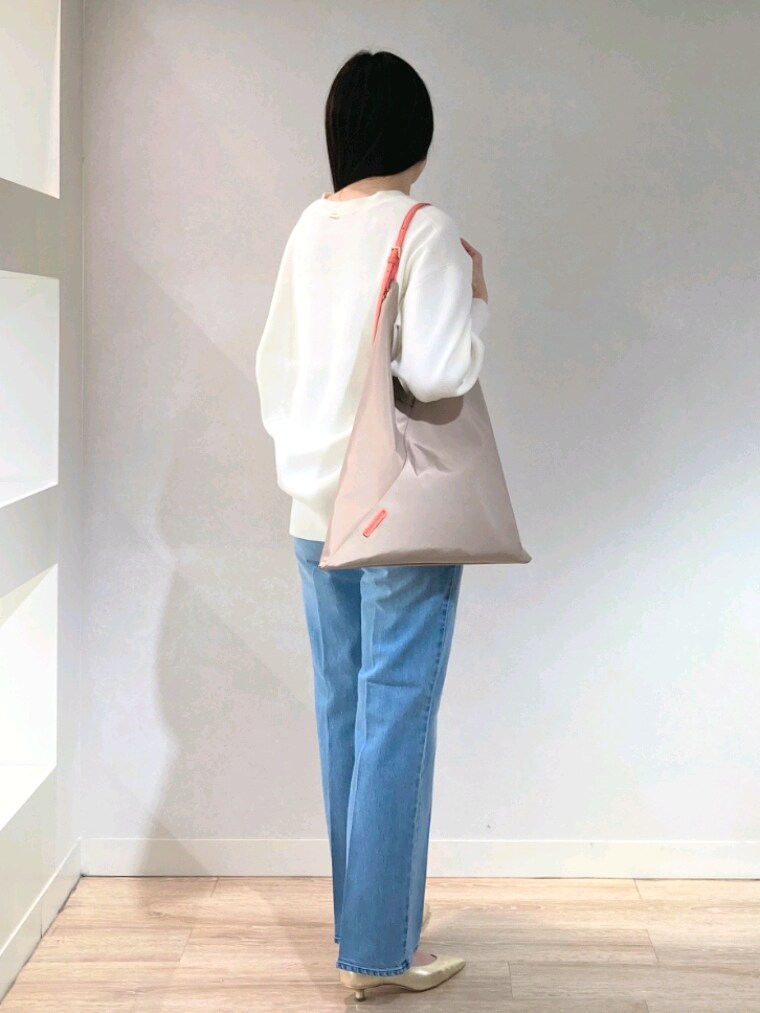 ホワイト系のニット/セーター、ゴールド系のキャミソール、ブルー系のデニムパンツを着用したレディースの春コーディネートの10枚目の写真