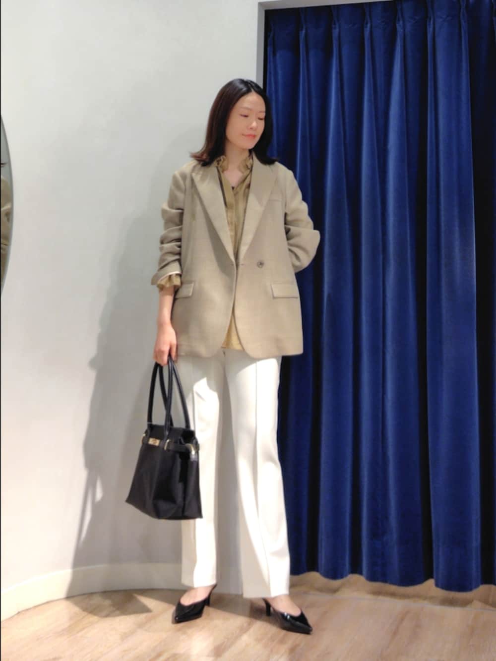 ベージュ系のテーラードジャケット、イエロー系のシャツ/ブラウス、ホワイト系のその他パンツを着用したレディースの春コーディネートの2枚目の写真