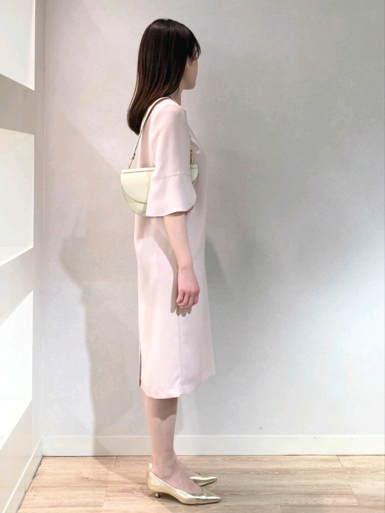 ピンク系のワンピース、ゴールド系のパンプス、ホワイト系のショルダーバッグを着用したレディースの春コーディネートの2枚目の写真
