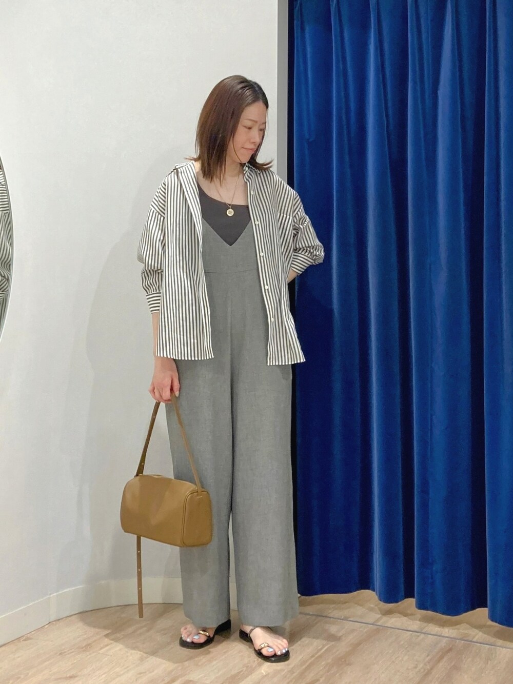 ブラウン系のシャツ/ブラウス、グレー系のつなぎ/オールインワン、ゴールド系のサンダルを着用したレディースの夏コーディネートの2枚目の写真