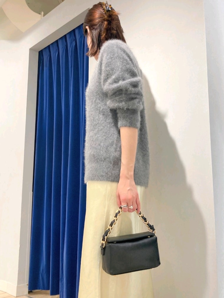 グレー系のニット/セーター、ブラック系のショルダーバッグ、イエロー系のスカートを着用したレディースの秋コーディネートの7枚目の写真