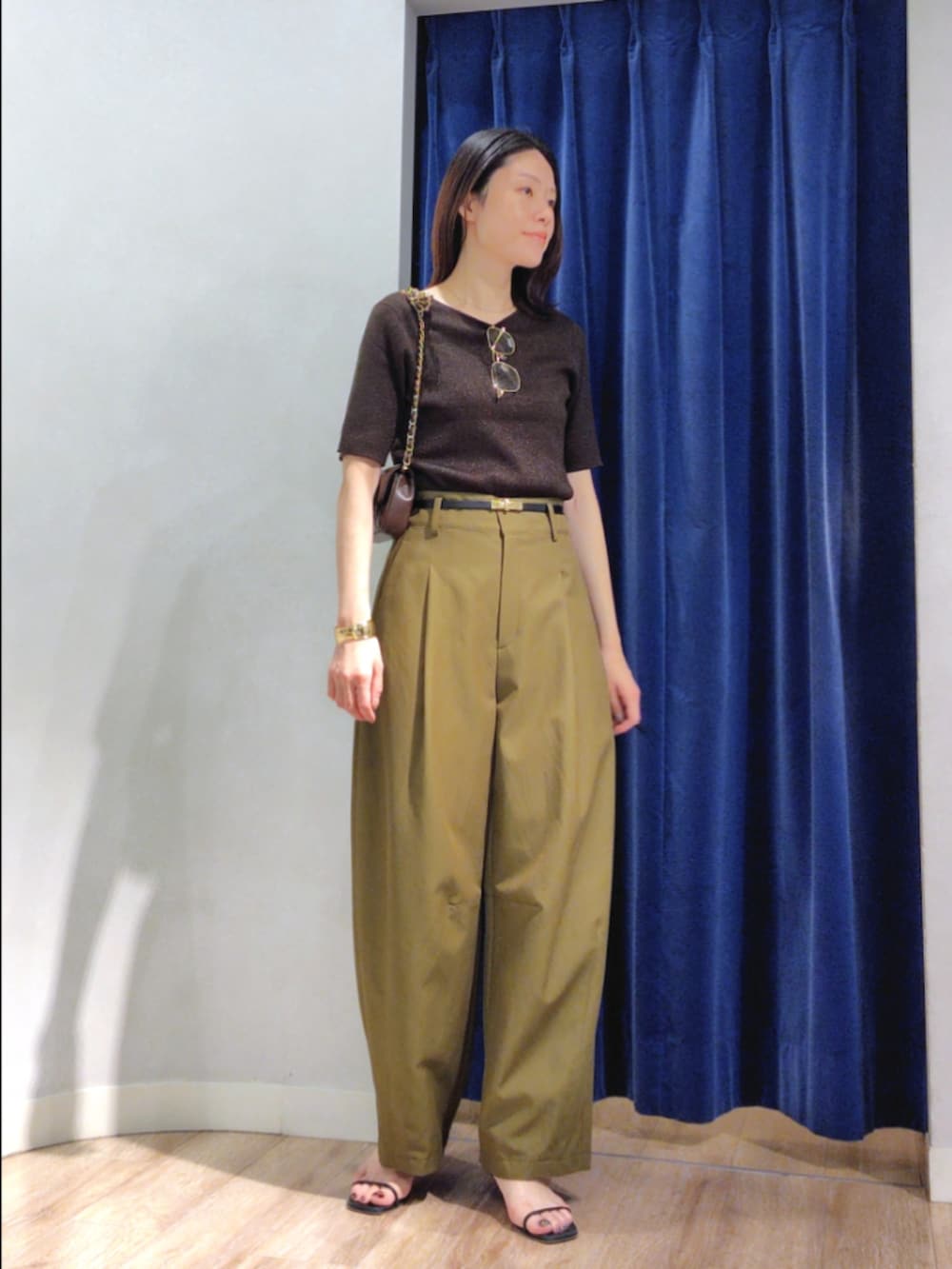 グリーン系のチノパンツ、ブラウン系のニット/セーター、ブラウン系のショルダーバッグを着用したレディースの秋コーディネートの3枚目の写真