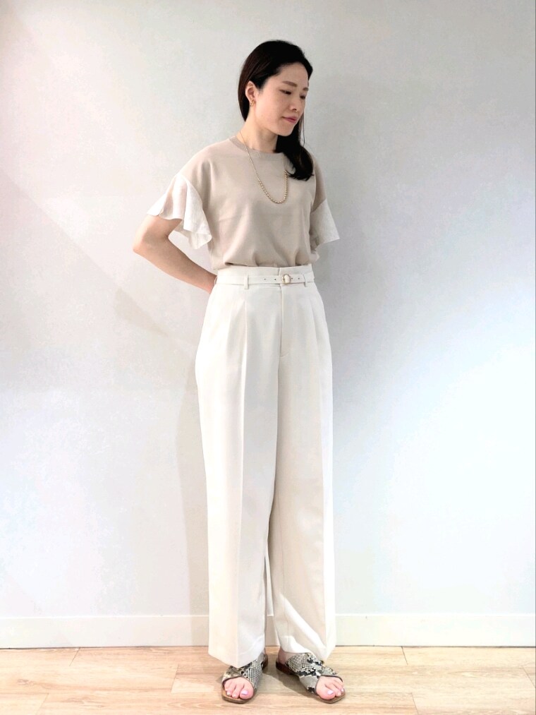 ベージュ系のニット/セーター、ブラック系のトートバッグ、ゴールド系のネックレスを着用したレディースの夏コーディネートの5枚目の写真