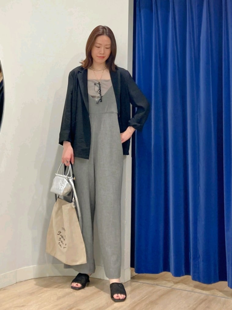 ブラック系のテーラードジャケット、グリーン系のキャミソール、グレー系のつなぎ/オールインワンを着用したレディースの春コーディネートの2枚目の写真