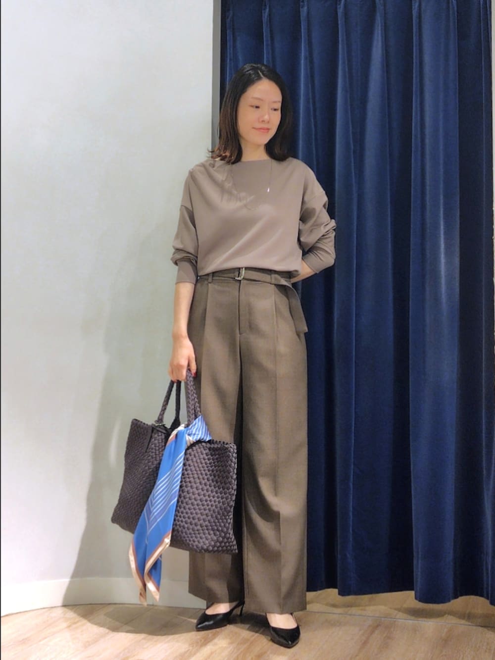 グリーン系のTシャツ/カットソー、ブラウン系のその他パンツ、グレー系のトートバッグを着用したレディースの秋コーディネートの2枚目の写真