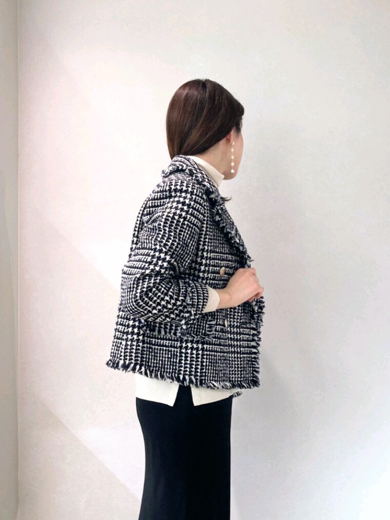 ブラック系のショルダーバッグ、ホワイト系のブーツ、ブラック系のスカートを着用したレディースの冬コーディネートの7枚目の写真