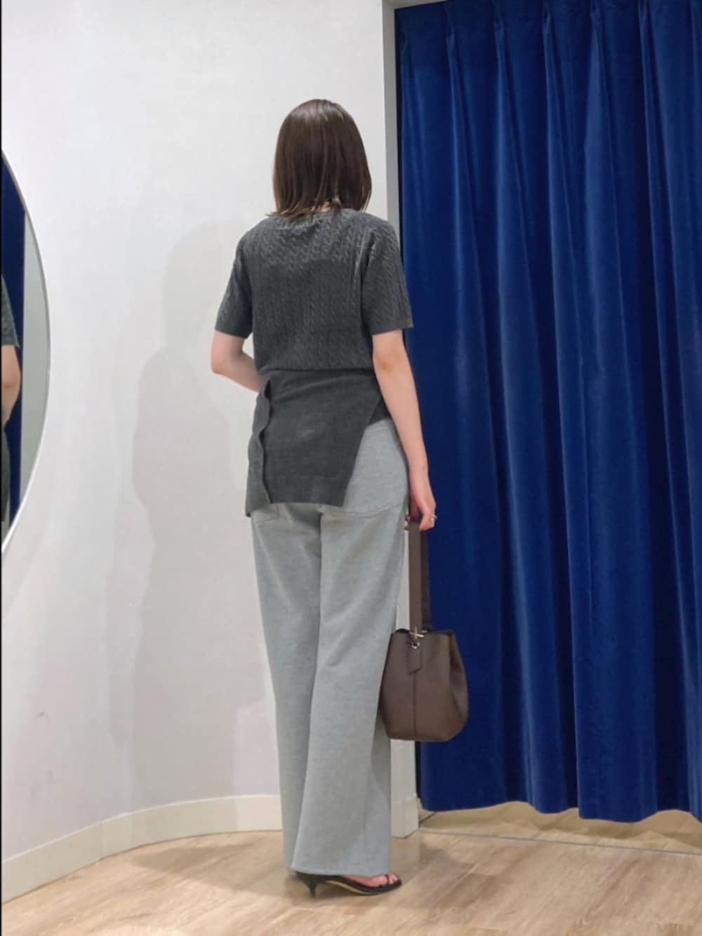 グレー系のニット/セーター、グレー系のカーディガン/ボレロ、グレー系のパンツを着用したレディースの秋コーディネートの4枚目の写真