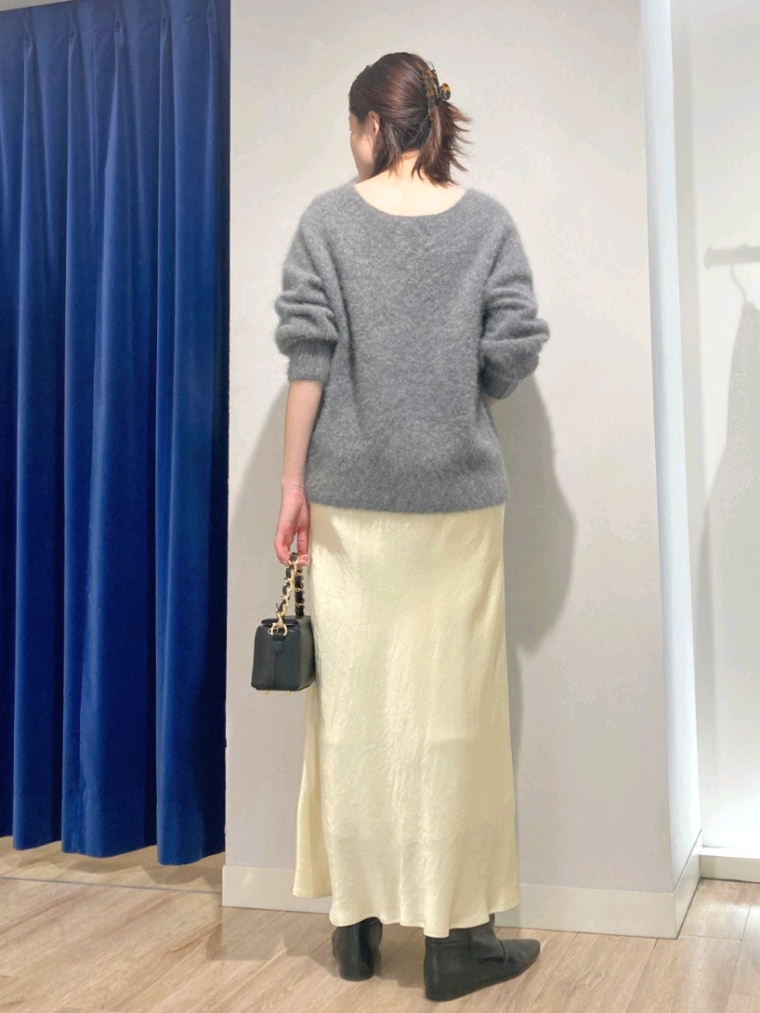 グレー系のニット/セーター、ブラック系のショルダーバッグ、イエロー系のスカートを着用したレディースの秋コーディネートの5枚目の写真