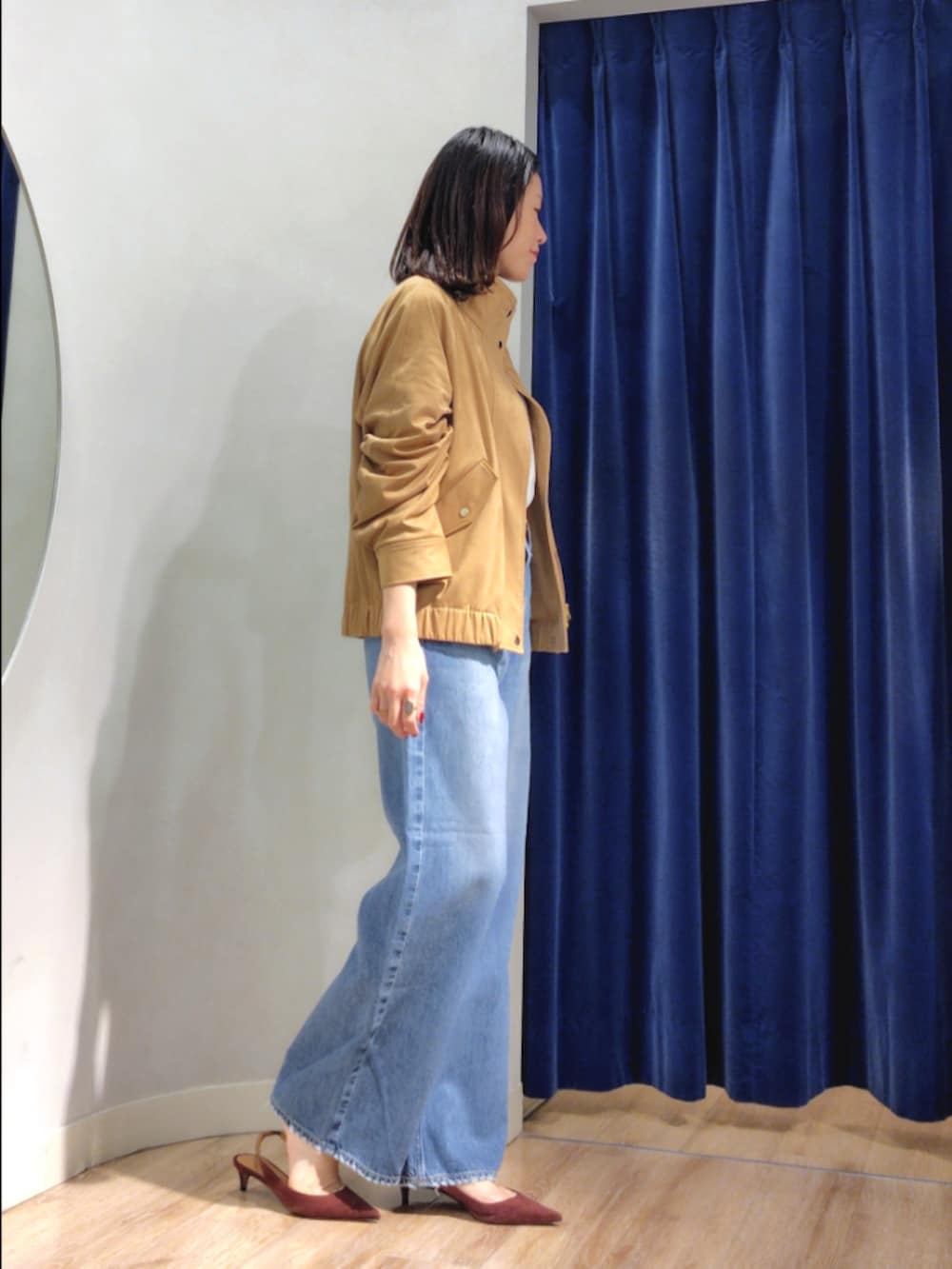 ブルー系のシャツ/ブラウス、イエロー系のブルゾン、ブルー系のデニムパンツを着用したレディースの秋コーディネートの5枚目の写真