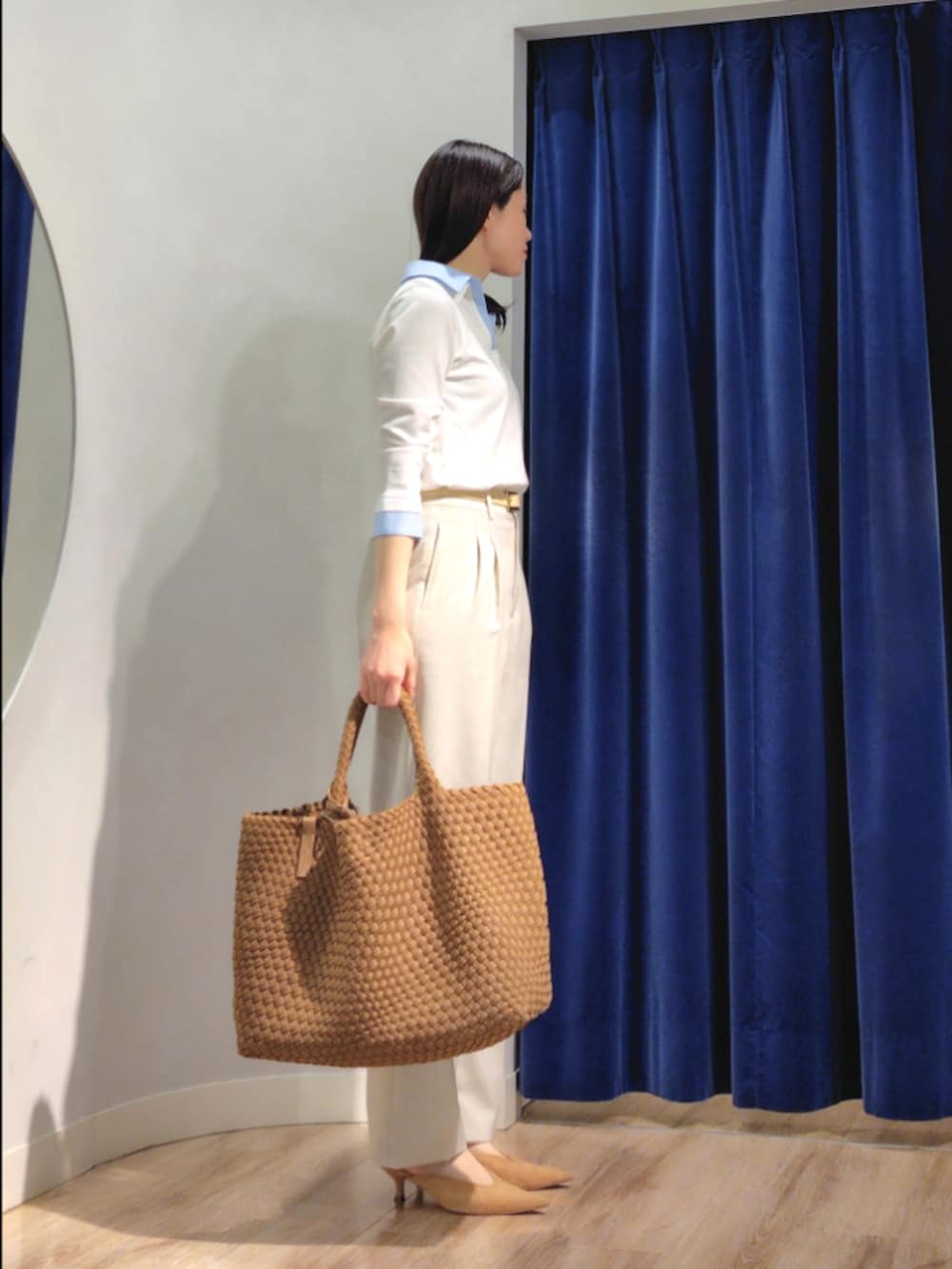 ブラウン系のトートバッグ、ベージュ系のその他パンツ、ホワイト系のニット/セーターを着用したレディースの春コーディネートの3枚目の写真