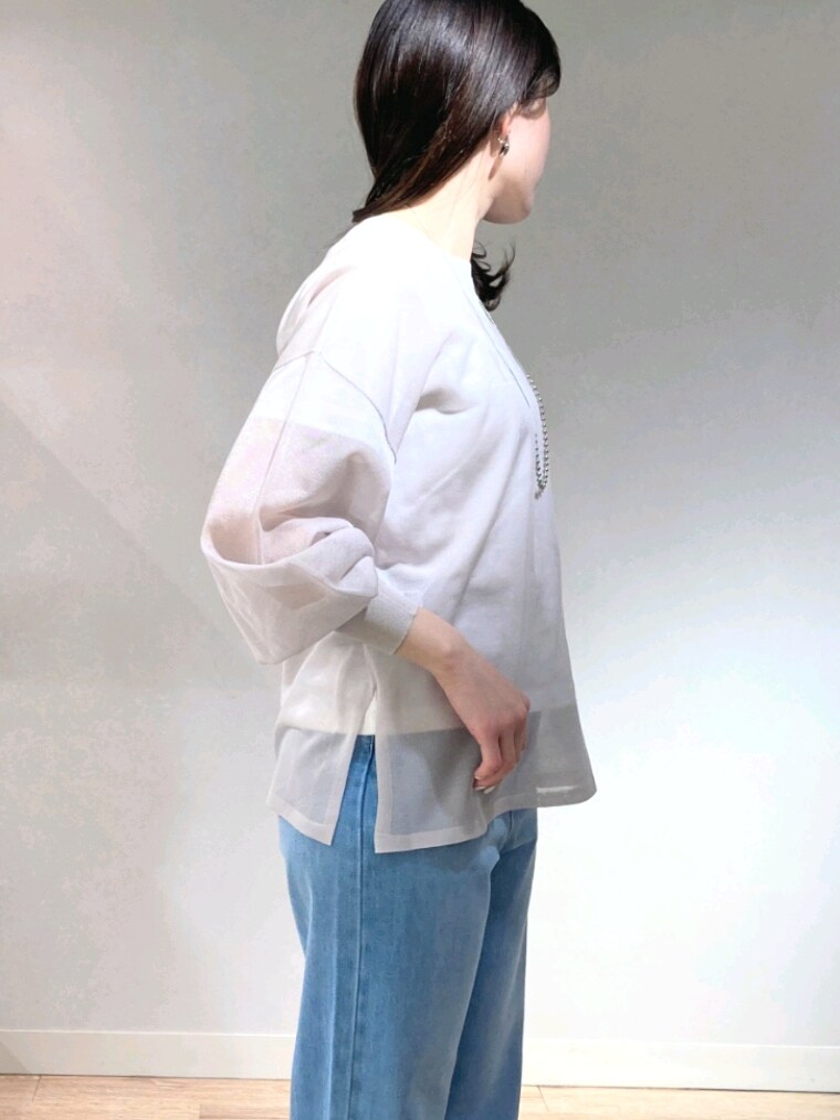 グレー系のニット/セーター、ホワイト系のTシャツ/カットソー、ブルー系のデニムパンツを着用したレディースの春コーディネートの5枚目の写真