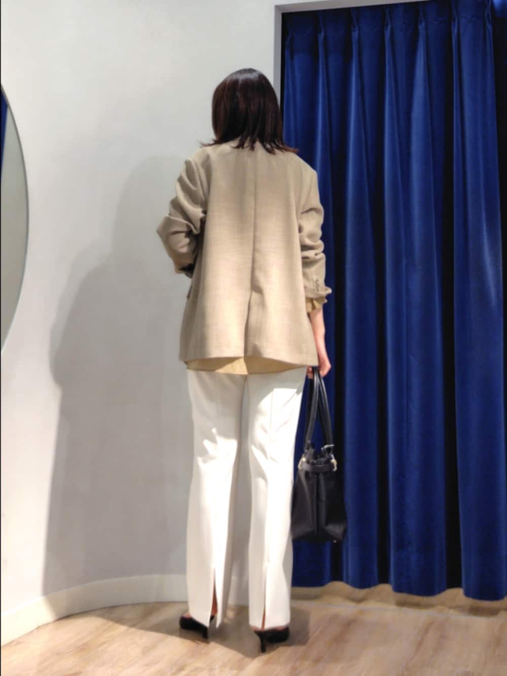 ベージュ系のテーラードジャケット、イエロー系のシャツ/ブラウス、ホワイト系のその他パンツを着用したレディースの春コーディネートの4枚目の写真