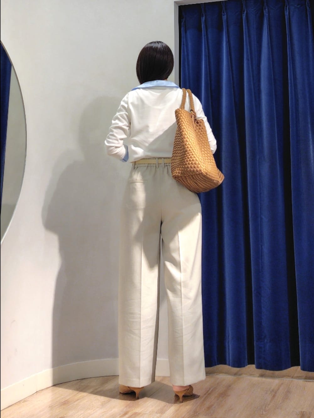 ブラウン系のトートバッグ、ベージュ系のその他パンツ、ホワイト系のニット/セーターを着用したレディースの春コーディネートの5枚目の写真