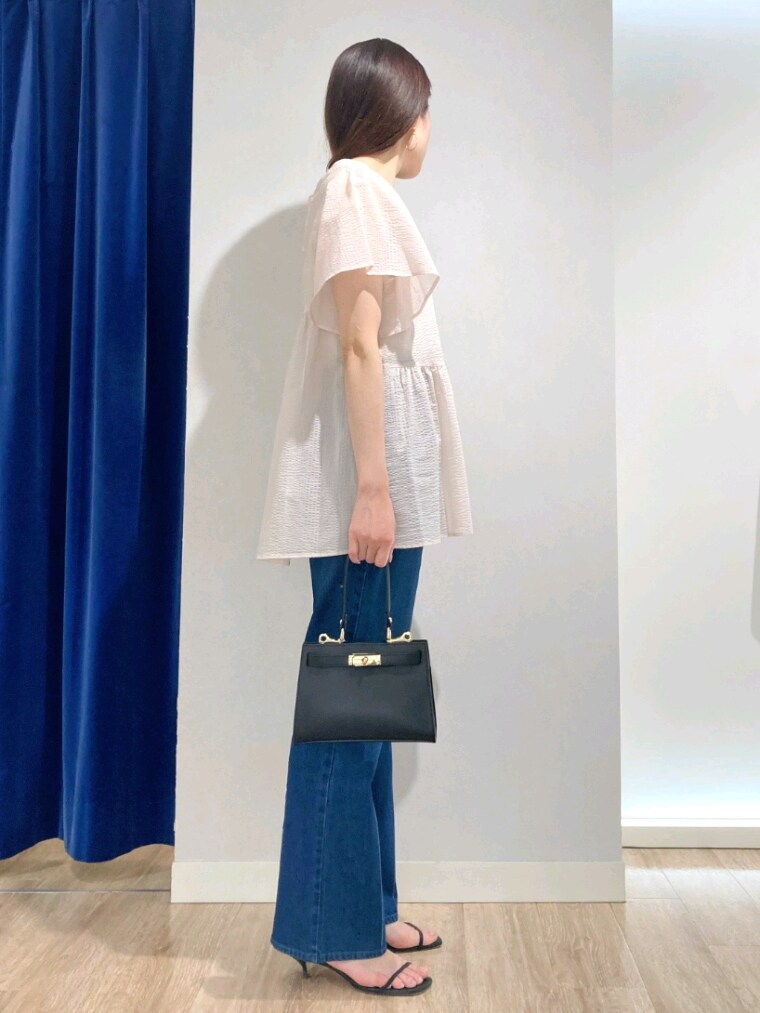 ピンク系のシャツ/ブラウス、ブルー系のデニムパンツ、ブラック系のショルダーバッグを着用したレディースの夏コーディネートの3枚目の写真