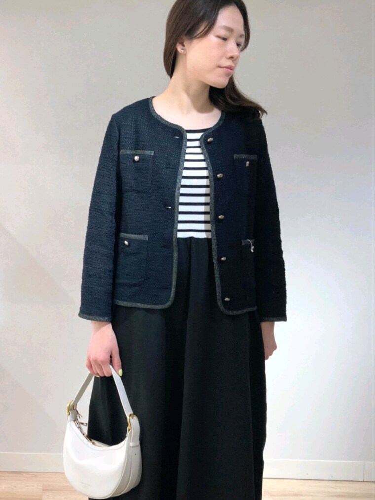 ブルー系のノーカラージャケット、ブラック系のワンピース、ホワイト系のショルダーバッグを着用したレディースの春コーディネートの3枚目の写真