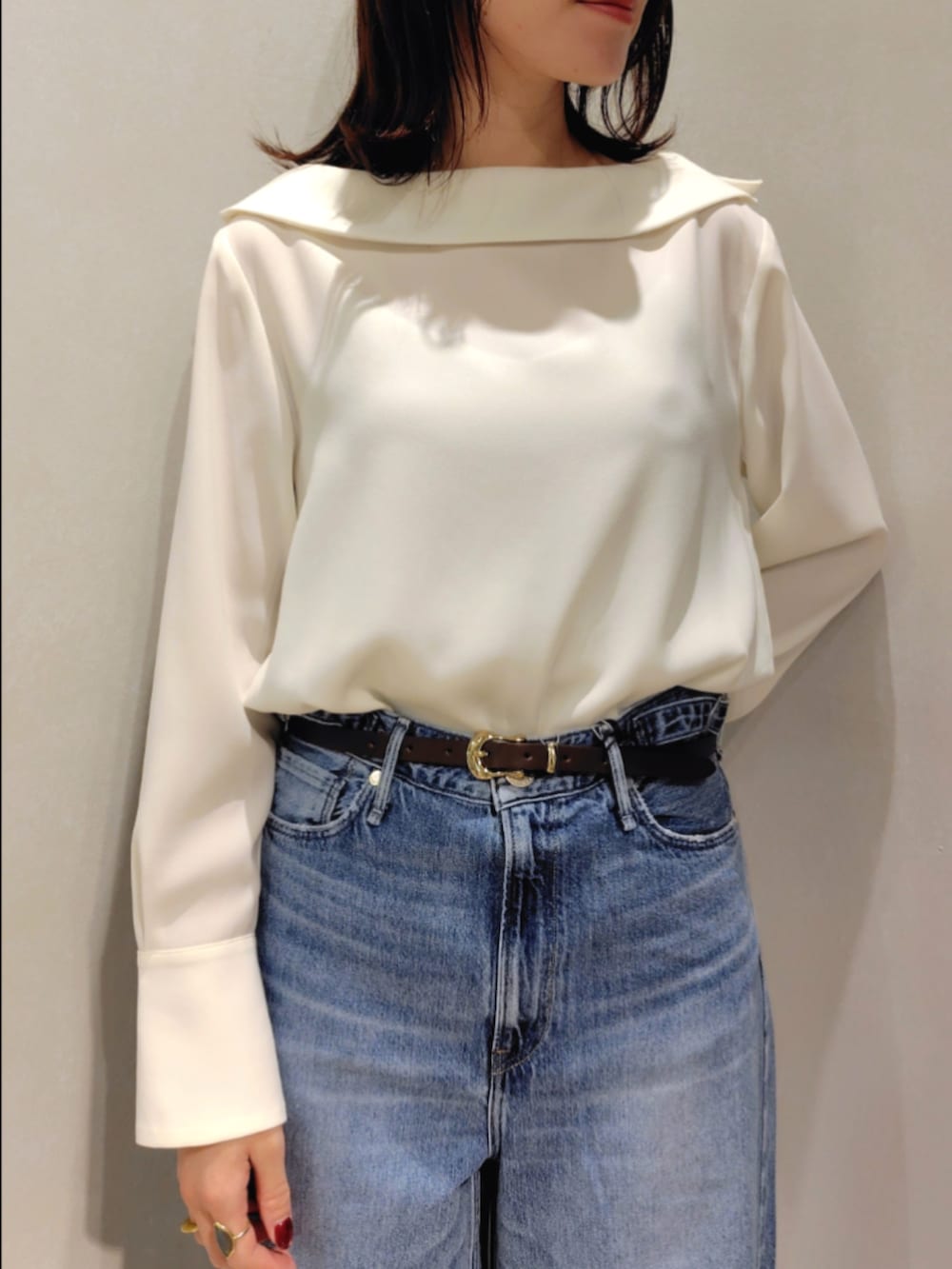 ブルー系のシャツ/ブラウス、イエロー系のブルゾン、ブルー系のデニムパンツを着用したレディースの秋コーディネートの5枚目の写真