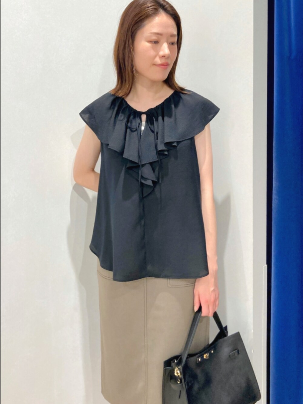 ブラック系のシャツ/ブラウス、ホワイト系のスカート、ブラック系のショルダーバッグを着用したレディースの夏コーディネートの8枚目の写真