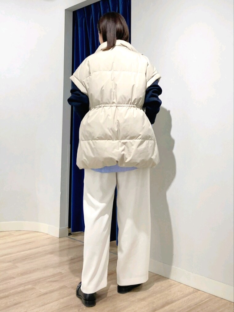 ブルー系のシャツ/ブラウス、ブルー系のTシャツ/カットソー、ベージュ系のダウンベストを着用したレディースの秋コーディネートの6枚目の写真