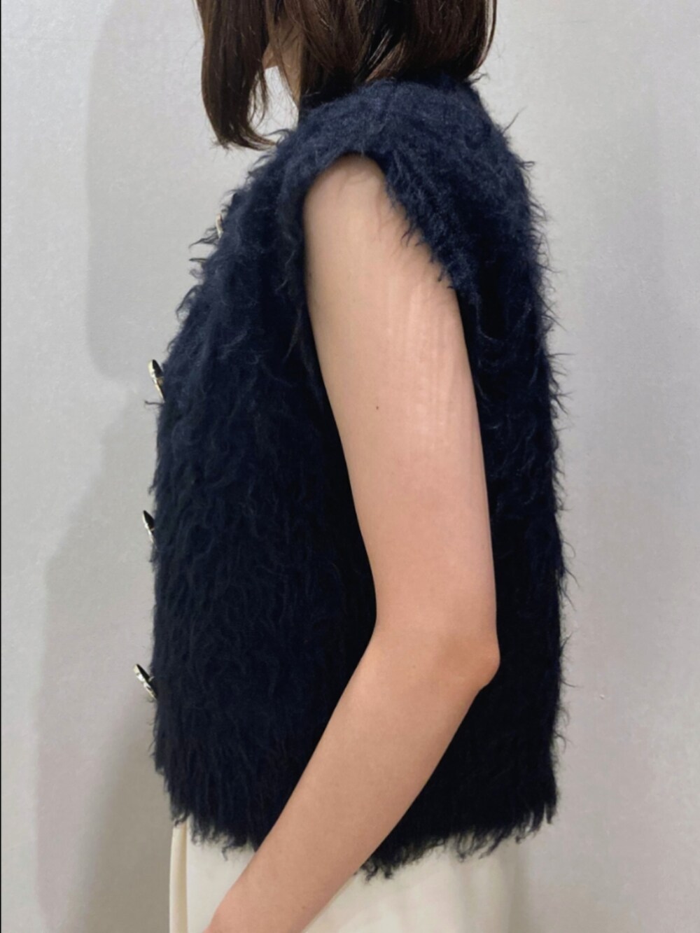 ブルー系のベスト、ブラック系のタンクトップ、ブラウン系のその他パンツを着用したレディースの秋コーディネートの8枚目の写真