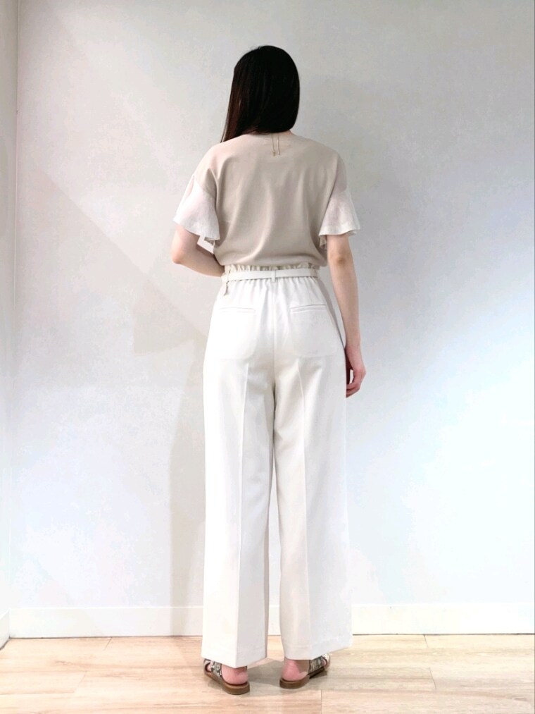 ベージュ系のニット/セーター、ブラック系のトートバッグ、ゴールド系のネックレスを着用したレディースの夏コーディネートの4枚目の写真