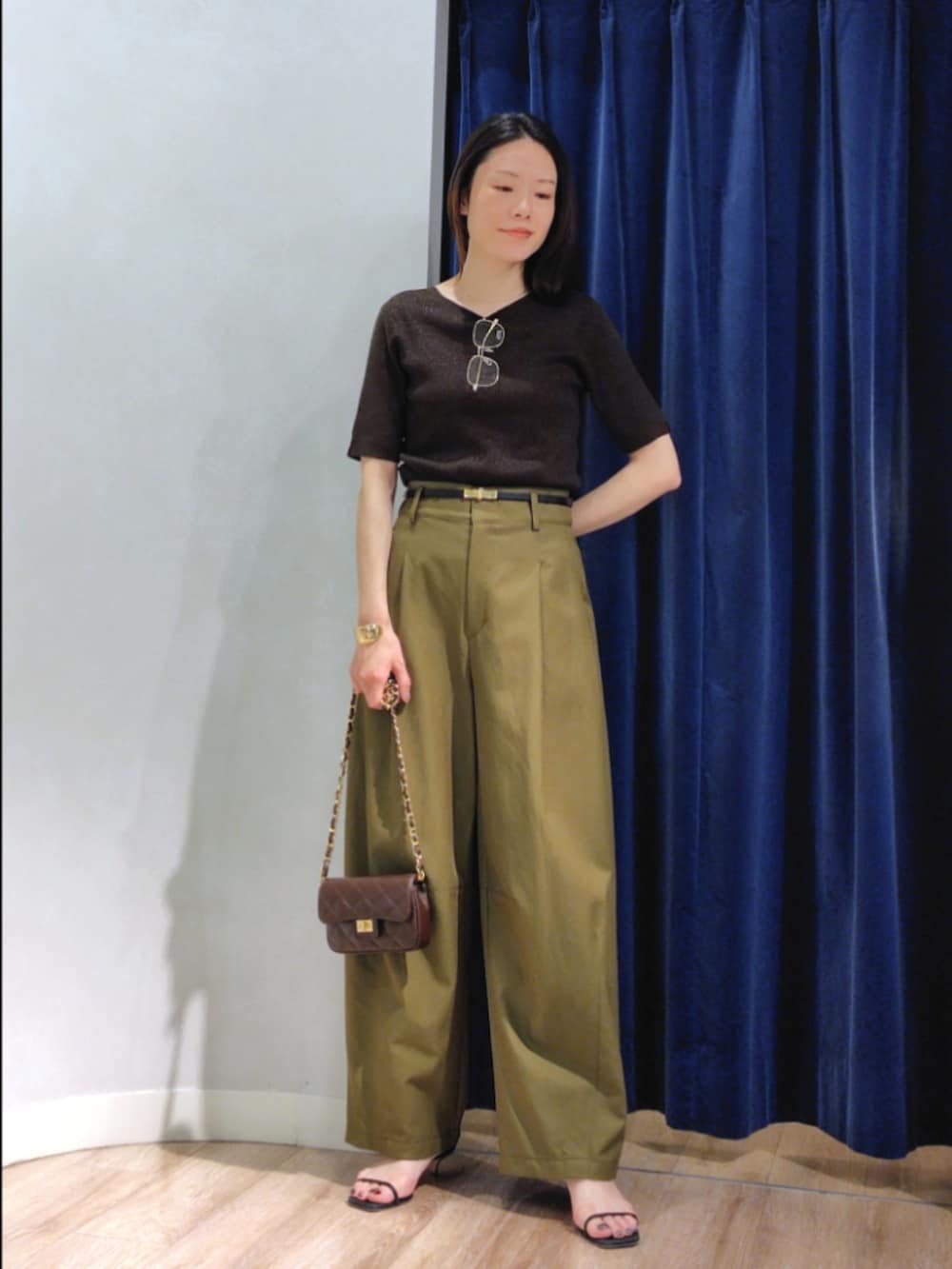 グリーン系のチノパンツ、ブラウン系のニット/セーター、ブラウン系のショルダーバッグを着用したレディースの秋コーディネートの2枚目の写真