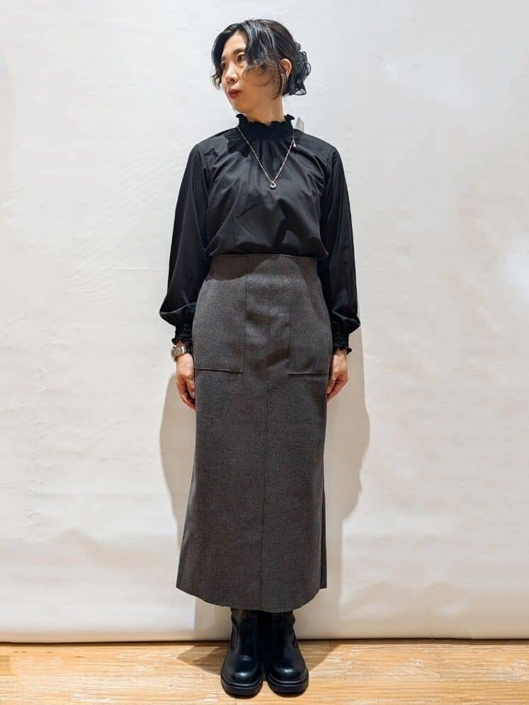 ホワイト系のカーディガン/ボレロ、ブラック系のシャツ/ブラウス、グレー系のスカートを着用したレディースの秋コーディネートの3枚目の写真