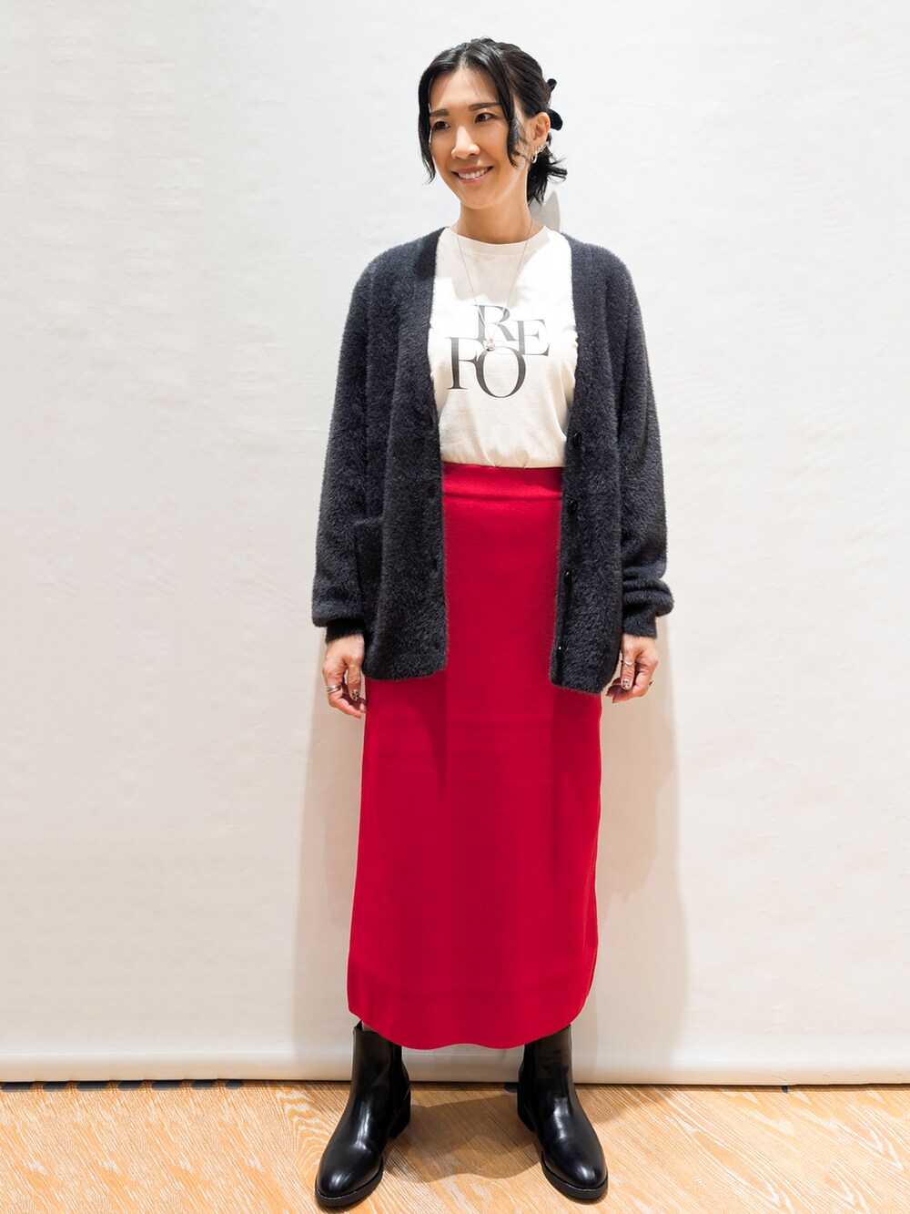 ホワイト系のTシャツ/カットソー、グレー系のカーディガン/ボレロ、レッド系のスカートを着用したレディースの秋コーディネートの2枚目の写真