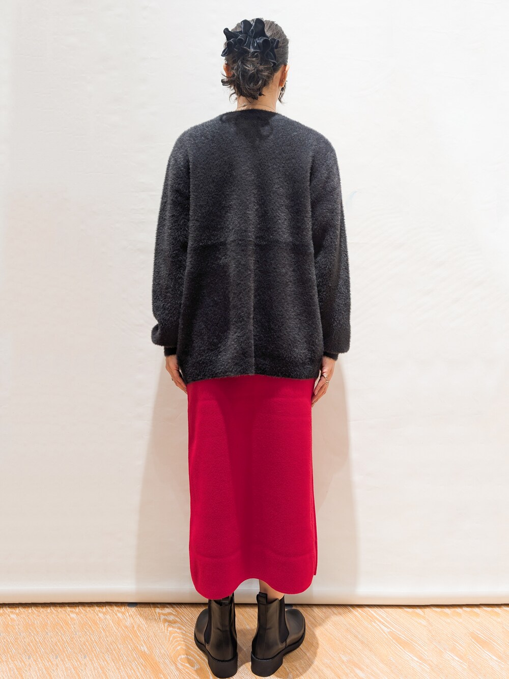 ホワイト系のTシャツ/カットソー、グレー系のカーディガン/ボレロ、レッド系のスカートを着用したレディースの秋コーディネートの3枚目の写真