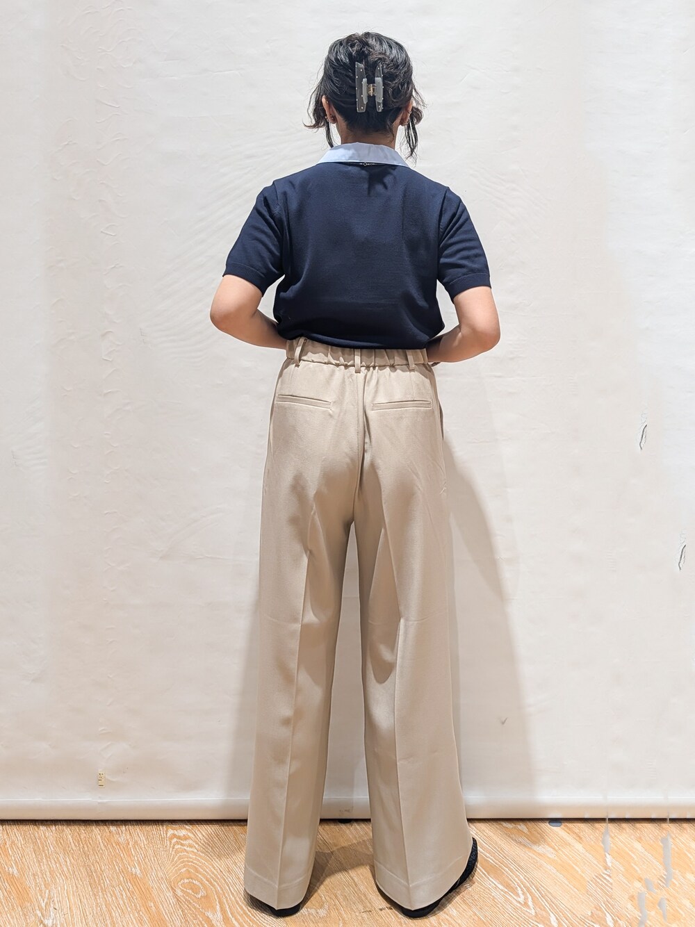 ブルー系のニット/セーター、ベージュ系のその他パンツ、ブラック系のトートバッグを着用したレディースの春コーディネートの2枚目の写真