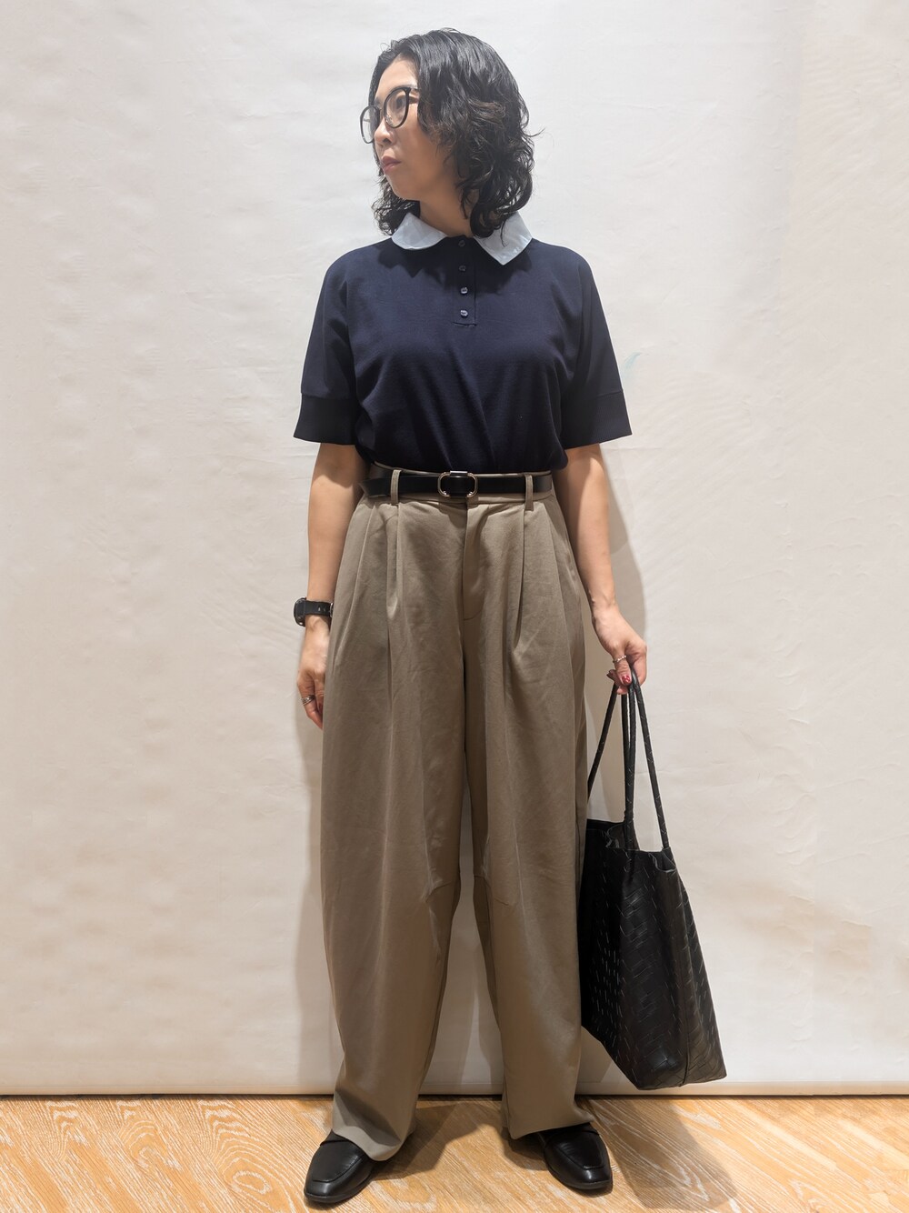 ブルー系のニット/セーター、グリーン系のその他パンツ、ブラック系のトートバッグを着用したレディースの夏コーディネートの2枚目の写真