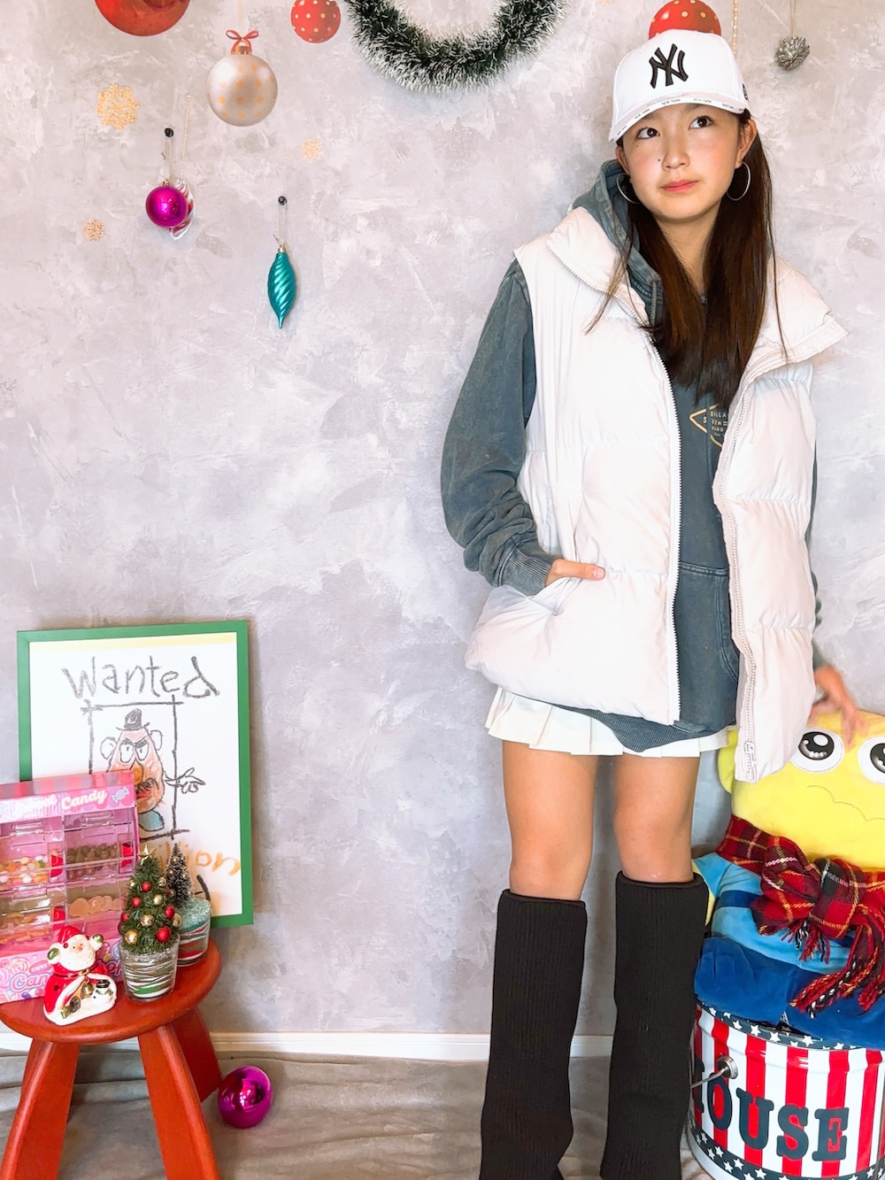 ホワイト系のダウンベスト、ホワイト系のスカート、ブラック系のブーツを着用したキッズの冬コーディネートの2枚目の写真