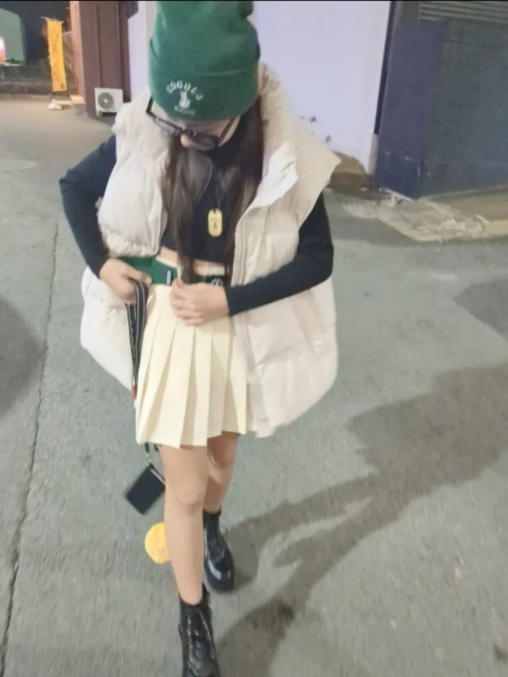 ホワイト系のダウンベスト、ホワイト系のスカート、ブラック系のブーツを着用したキッズの春コーディネートの2枚目の写真