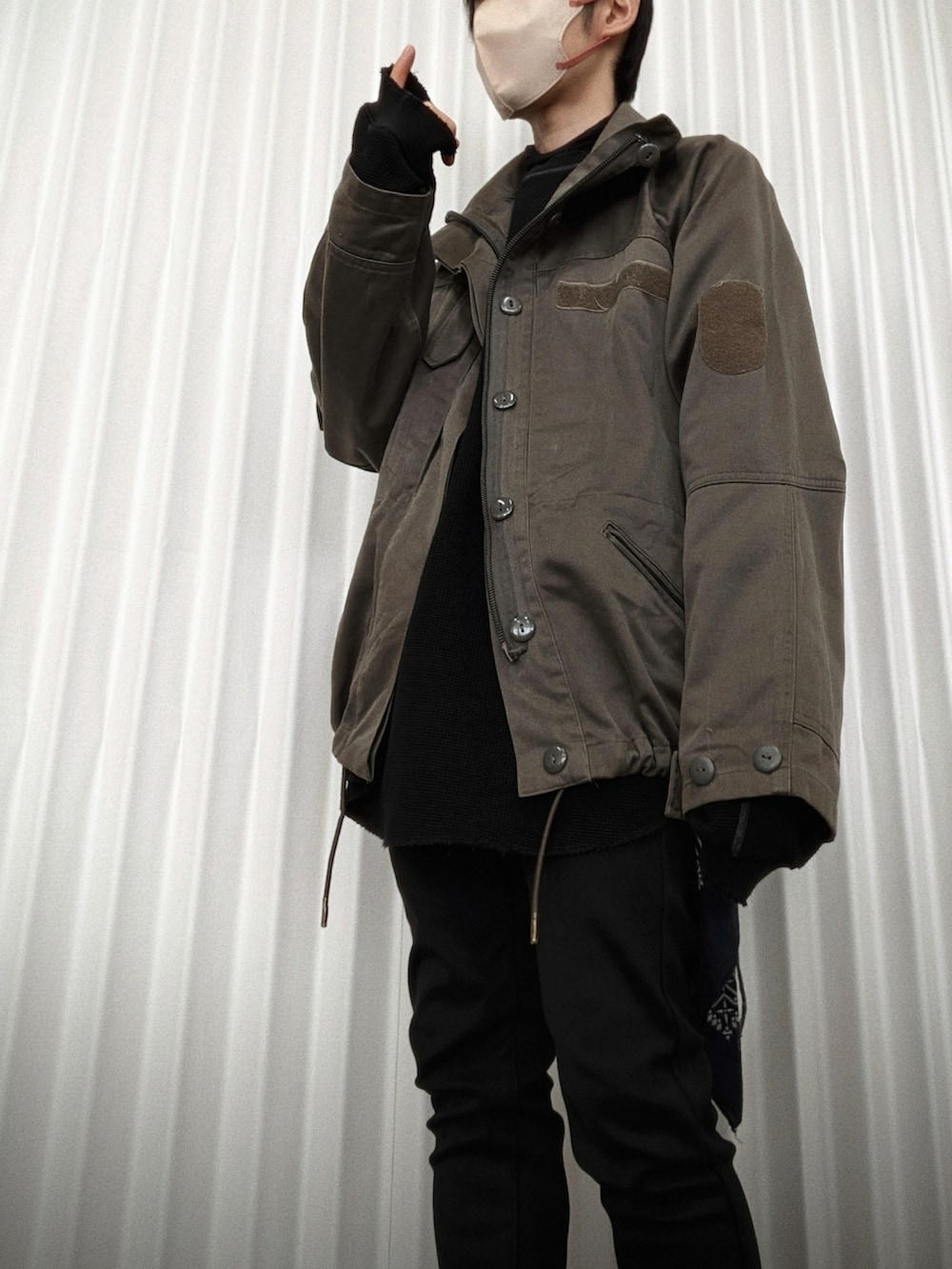 ブラック系のその他パンツ、グリーン系のミリタリージャケット、ブラック系のTシャツ/カットソーを着用したメンズの春コーディネートの2枚目の写真