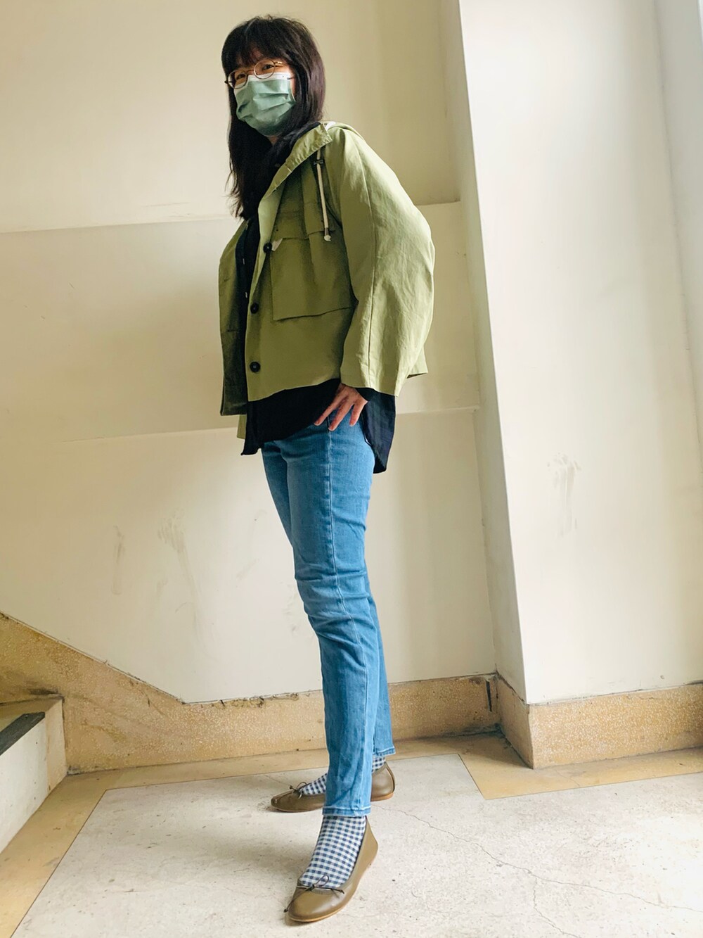 グリーン系のナイロンジャケット、ブルー系のデニムパンツを着用したレディースの冬コーディネートの2枚目の写真