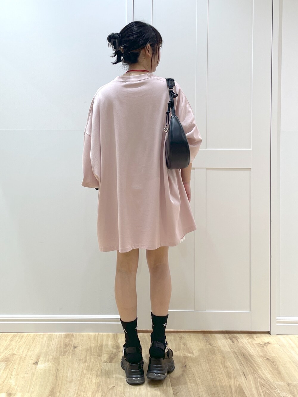 ブラウン系のTシャツ/カットソー、ブラック系のハンドバッグ、ブラック系のサンダルを着用したレディースの春コーディネートの2枚目の写真
