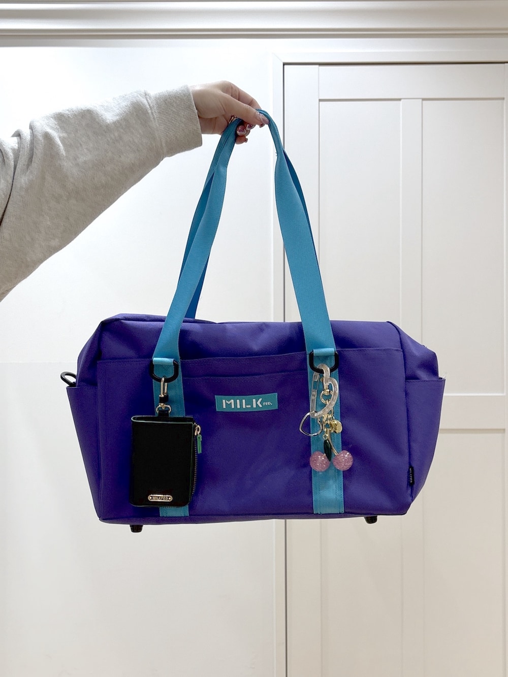 ベージュ系のスウェット、ベージュ系のスウェットパンツ、パープル系のショルダーバッグを着用したレディースの冬コーディネートの8枚目の写真