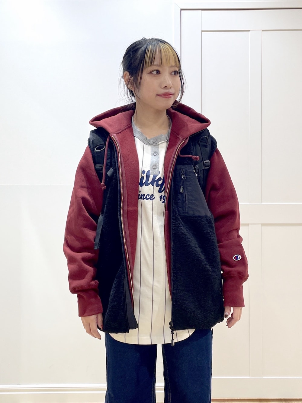 ベージュ系のブーツ、ブルー系のデニムパンツ、ブラック系のベストを着用したレディースの秋コーディネートの5枚目の写真