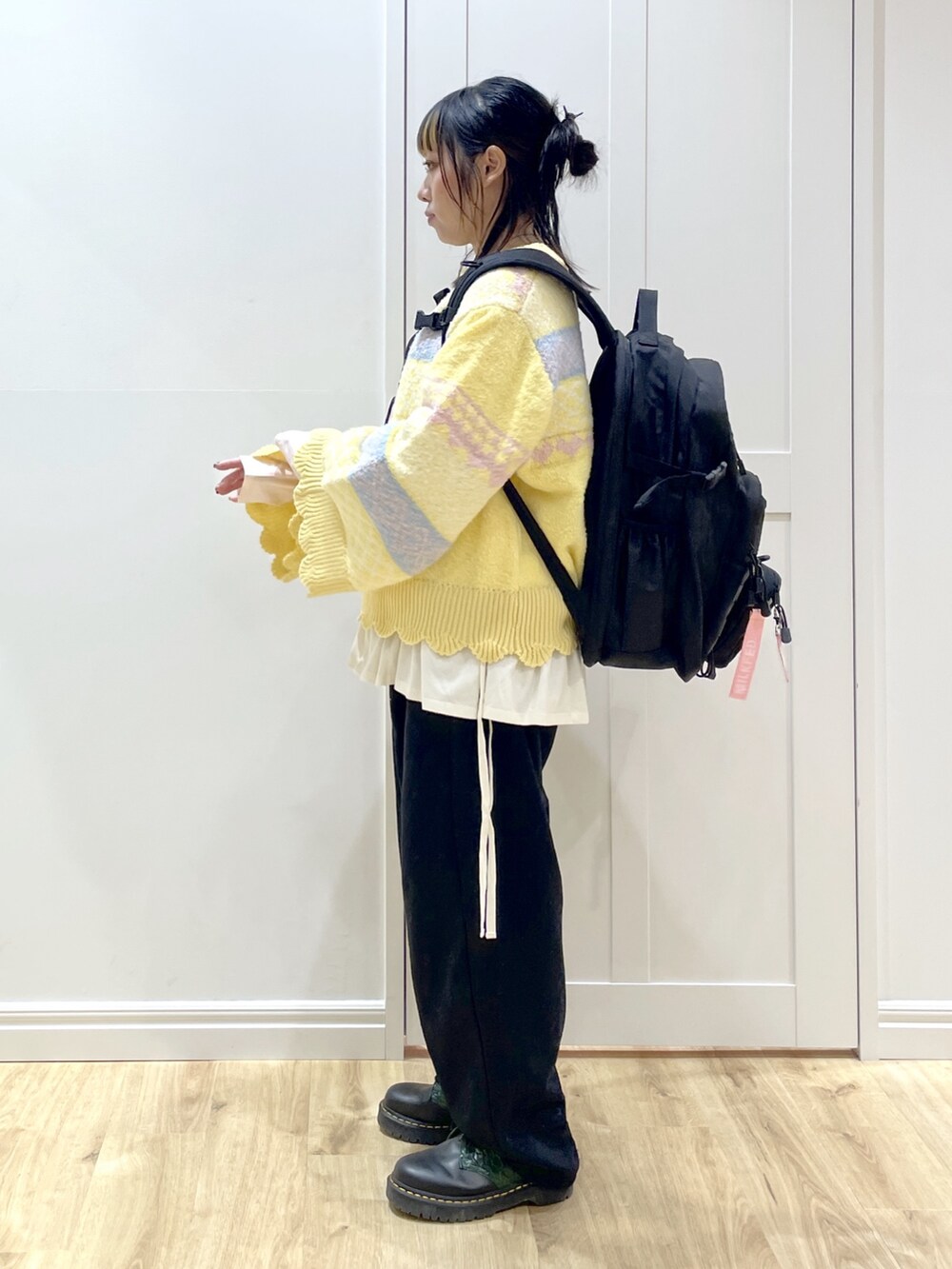 ピンク系のTシャツ/カットソー、イエロー系のニット/セーター、ブラック系のスウェットパンツを着用したレディースの秋コーディネートの5枚目の写真