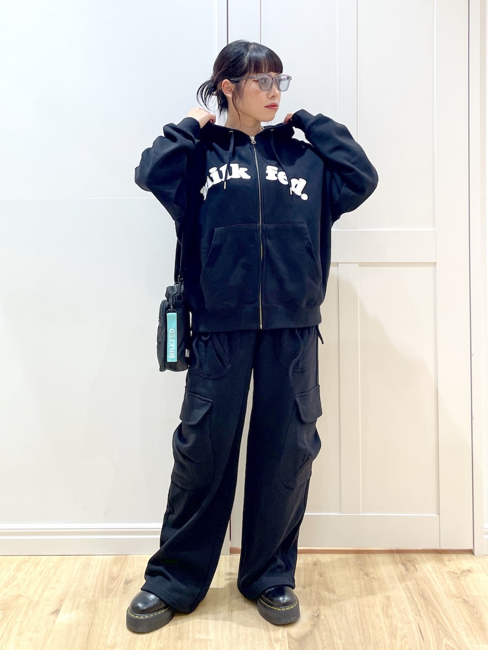 ブラック系のブーツ、ブラック系のスウェットパンツ、ブラック系のパーカーを着用したレディースの夏コーディネートの3枚目の写真