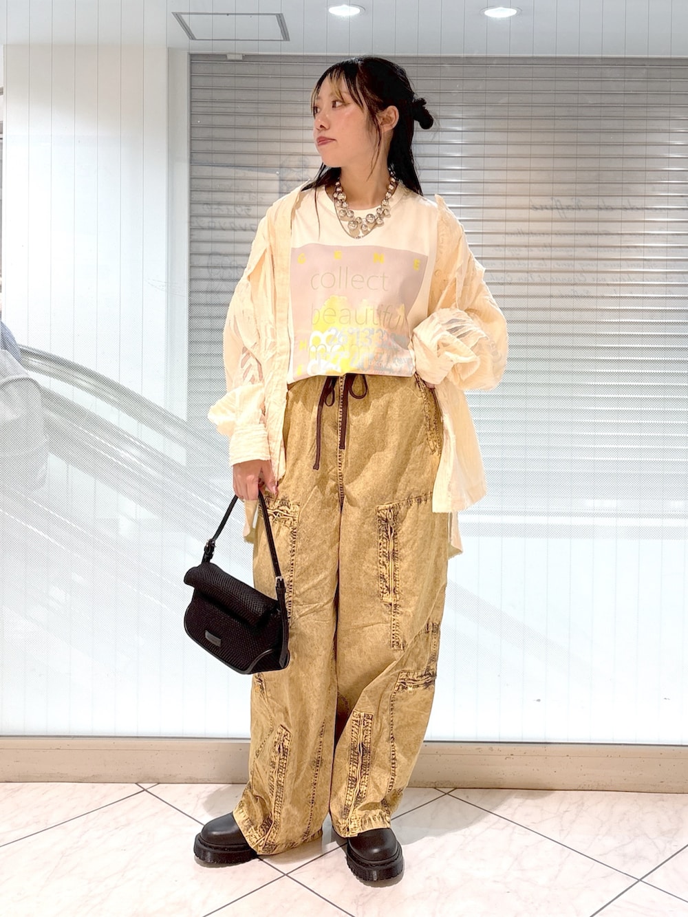 ブラック系のブーツ、ホワイト系のTシャツ/カットソー、ブラック系のショルダーバッグを着用したレディースの春コーディネートの4枚目の写真