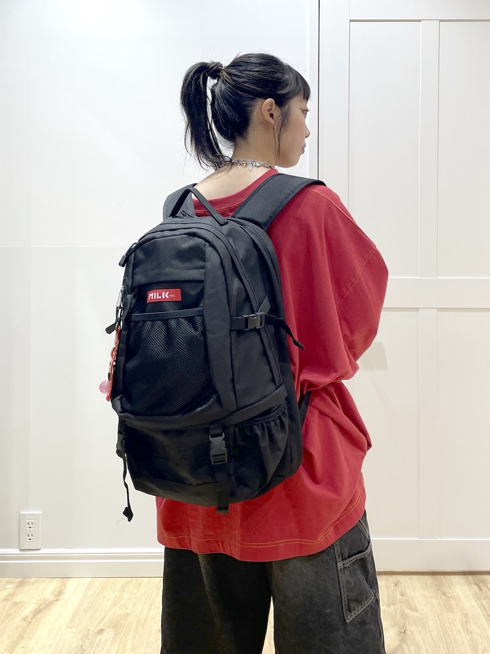 レッド系のバックパック/リュック、ブラック系のデニムパンツ、レッド系のTシャツ/カットソーを着用したレディースの秋コーディネートの6枚目の写真