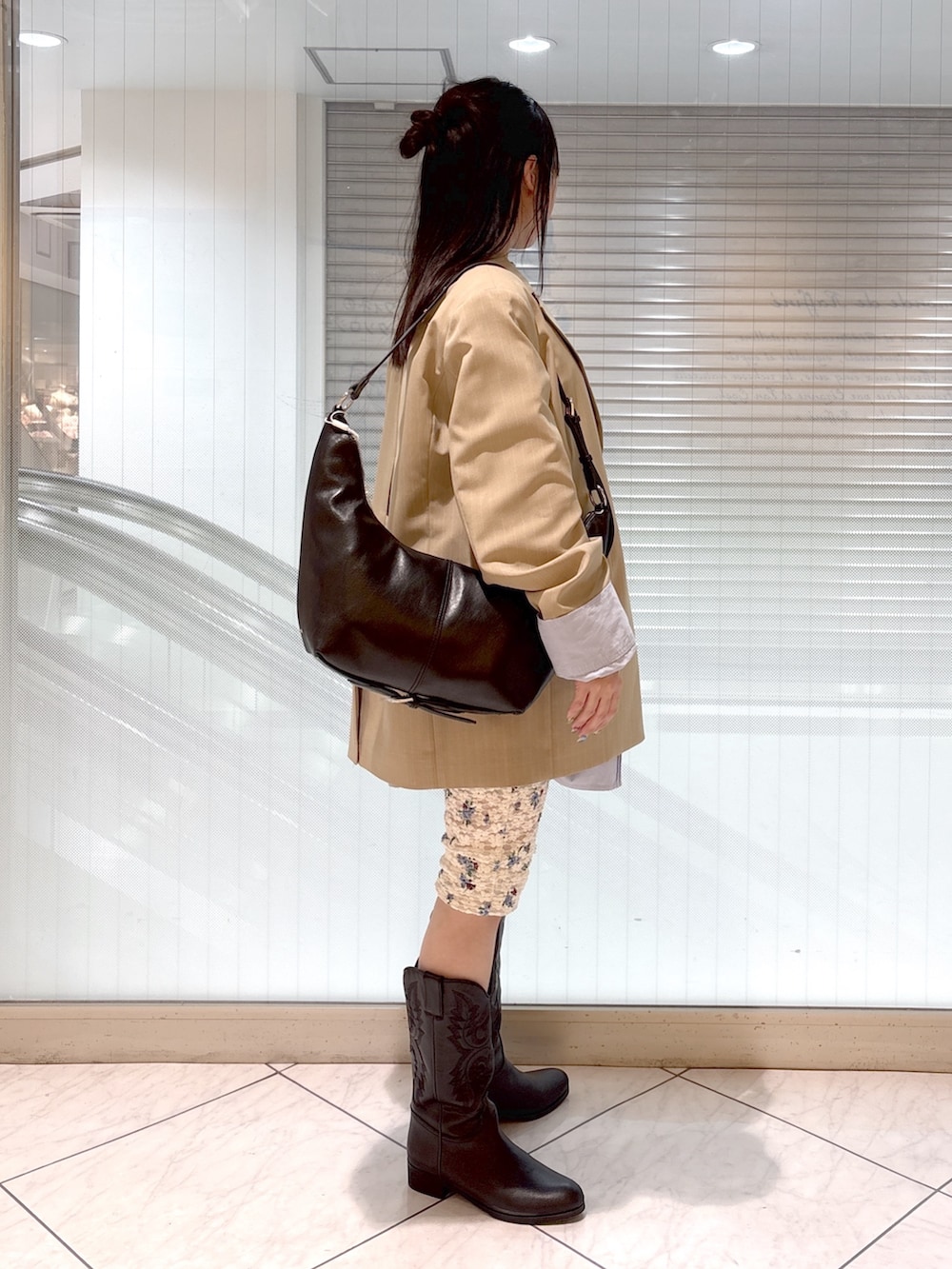 ブラック系のブーツ、ブルー系のシャツ/ブラウス、ベージュ系のテーラードジャケットを着用したレディースの春コーディネートの4枚目の写真